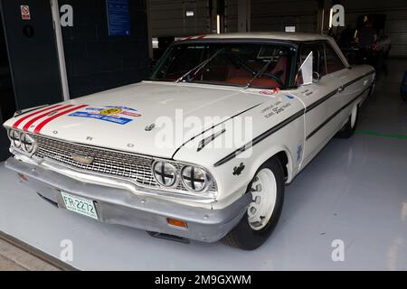 Vista frontale di tre quarti di Fred e Bill Shepherd's White, 1965, Ford Galaxie, nei box internazionali, al 2022 Silverstone Classic Foto Stock