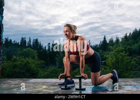 Donna che pratica all'aperto con manubri, Bainbridge Island, Washington, USA Foto Stock