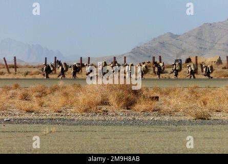 Marines del Battalion Landing Team 3/6 (BLT 3/6) 'hump' verso le loro volpi combattenti appena fuori dalla pista presso l'aeroporto internazionale di Khandahar, Khandahar, Afghanistan durante L'OPERAZIONE CHE PERDURANO LA LIBERTÀ. Soggetto operativo/Serie: ENDURING FREEDOM base: Aeroporto internazionale di Kandahar Paese: Afghanistan (AFG) scena comando maggiore mostrato: 26th MEU (SOC) Foto Stock