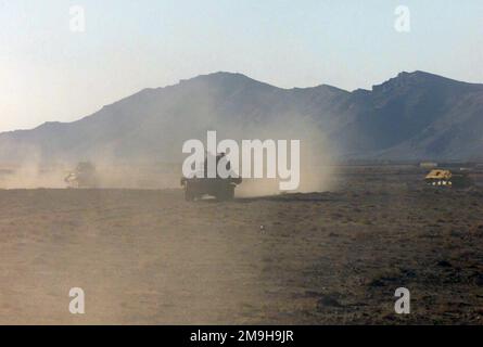 Generando una nube di polvere, Marines con Alpha Company, Battaglione di ricognizione Second Light Armored, 26th Marine Expeditionary Unit (Special Operations Capable) condurre una pattuglia montata utilizzando un LAV-25 (Light Armored Vehicle-25) vicino all'Aeroporto Internazionale di Kandahar, Kandahar, Afghanistan, durante L'OPERAZIONE CHE PERDURERÀ LA LIBERTÀ. Sullo sfondo c'è una battaglia danneggiata veicolo blindato sovietico leggero. Oggetto operazione/Serie: ENDURING FREEDOM base: Aeroporto internazionale di Kandahar Paese: Afghanistan (AFG) scena comando maggiore mostrato: 26 MEU Foto Stock