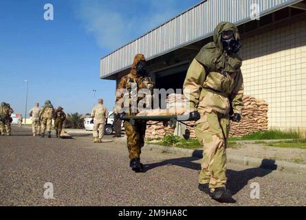 Il compito di portare con sé una barella riempita di sacchi di sabbia mentre si è in Mission-Oriented Protective Posture Response Level 4 (MOPP-4) è svolto da un Marine (anteriore) e un australiano. Il Marine è vestito con la sua Joint Service Lightweight Integrated Suit Technology (JSLIST), indossando una maschera di campo chimico-biologico M40 con filtro C2A1. L'australiano indossa la tuta MKIV No1 Nuclear Biological Chemical (NBC) con la maschera Avon FM12. I Marines e gli Australiani stanno partecipando al NBC Training a Camp Doha, Kuwait, durante L'OPERAZIONE CHE PERCORRE LA LIBERTÀ. Funzionamento soggetto/Serie: DUREVOLE Foto Stock