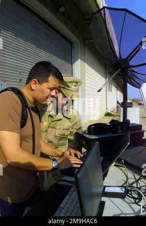 James H. Glass, USMC, (uniforme) MWSS-371 (Marine Wing Support Squadron), Yuma, Arizona crea una stazione meteorologica portatile MIDDS-T (Meteorologia ed Oceanografia Integrated Data Display System Tactical) con il tenente della Marina Timothy B. Smith, USN, NAVPACMETOCCEN (Naval Pacific Meteorology and Oceanography Center), San Diego, CA. L'unità sarà utilizzata a sostegno delle operazioni a Camp Doha durante l'operazione CHE PERDURERÀ LA LIBERTÀ. Subject Operation/Series: ENDURING FREEDOM base: Camp Doha Paese: Kuwait (KWT) Scene Major Command mostrato: CJTF Foto Stock