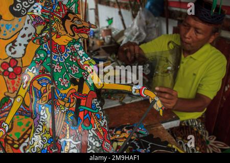 Yogyakarta, Indonesia. 18th Jan, 2023. Un artista indonesiano Iskandar Hardjodimuljo crea burattini da rifiuti di plastica presso la galleria Wayang Uwuh a Yogyakarta, Indonesia il 18 gennaio 2023. La realizzazione di burattini Uwuh o spazzatura con materie prime di plastica di scarto come il cartone e il cartone usato, così come le bottiglie di plastica di scarto e contenitori di cibo è uno sforzo per fare campagna al pubblico per essere più saggio nella riduzione dei rifiuti di plastica in Indonesia. (Foto di FREEDY TUNGGA/INA PHOTO AGENCY/SIPA USA) Credit: Sipa USA/Alamy Live News Foto Stock