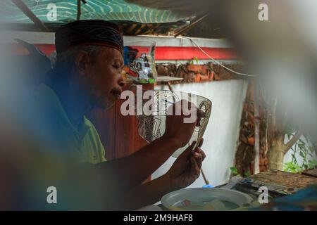 Yogyakarta, Indonesia. 18th Jan, 2023. Un artista indonesiano Iskandar Hardjodimuljo crea burattini da rifiuti di plastica presso la galleria Wayang Uwuh a Yogyakarta, Indonesia il 18 gennaio 2023. La realizzazione di burattini Uwuh o spazzatura con materie prime di plastica di scarto come il cartone e il cartone usato, così come le bottiglie di plastica di scarto e contenitori di cibo è uno sforzo per fare campagna al pubblico per essere più saggio nella riduzione dei rifiuti di plastica in Indonesia. (Foto di FREEDY TUNGGA/INA PHOTO AGENCY/SIPA USA) Credit: Sipa USA/Alamy Live News Foto Stock