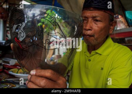 Yogyakarta, Indonesia. 18th Jan, 2023. Un artista indonesiano Iskandar Hardjodimuljo crea burattini da rifiuti di plastica presso la galleria Wayang Uwuh a Yogyakarta, Indonesia il 18 gennaio 2023. La realizzazione di burattini Uwuh o spazzatura con materie prime di plastica di scarto come il cartone e il cartone usato, così come le bottiglie di plastica di scarto e contenitori di cibo è uno sforzo per fare campagna al pubblico per essere più saggio nella riduzione dei rifiuti di plastica in Indonesia. (Foto di FREEDY TUNGGA/INA PHOTO AGENCY/SIPA USA) Credit: Sipa USA/Alamy Live News Foto Stock