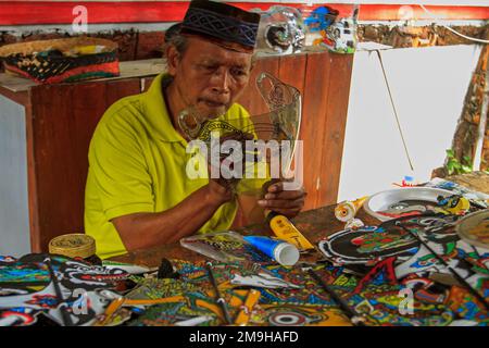 Yogyakarta, Indonesia. 18th Jan, 2023. Un artista indonesiano Iskandar Hardjodimuljo crea burattini da rifiuti di plastica presso la galleria Wayang Uwuh a Yogyakarta, Indonesia il 18 gennaio 2023. La realizzazione di burattini Uwuh o spazzatura con materie prime di plastica di scarto come il cartone e il cartone usato, così come le bottiglie di plastica di scarto e contenitori di cibo è uno sforzo per fare campagna al pubblico per essere più saggio nella riduzione dei rifiuti di plastica in Indonesia. (Foto di FREEDY TUNGGA/INA PHOTO AGENCY/SIPA USA) Credit: Sipa USA/Alamy Live News Foto Stock