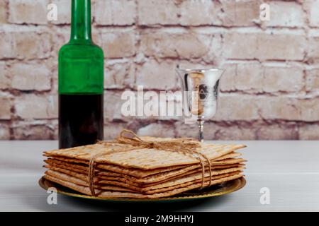 Durante la festa ebraica di Pesach tazza di kosher kiddush vino è con pane azzimo chiamato mattzah soft focus Foto Stock