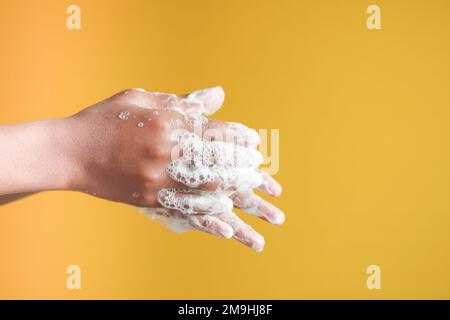 giovane uomo che lava le mani con acqua tiepida Foto Stock