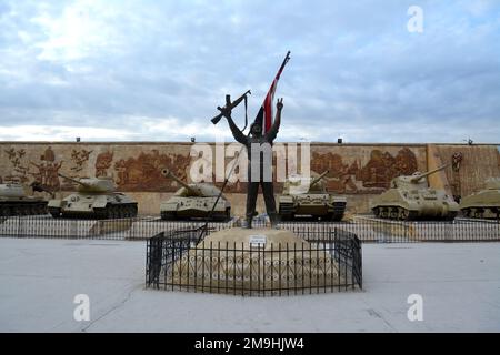 Cairo, Egitto, gennaio 7 2023: Un soldato egiziano che celebra la vittoria di fronte ai carri armati 1973 guerra con la bandiera egiziana dal militante nazionale egiziano Foto Stock