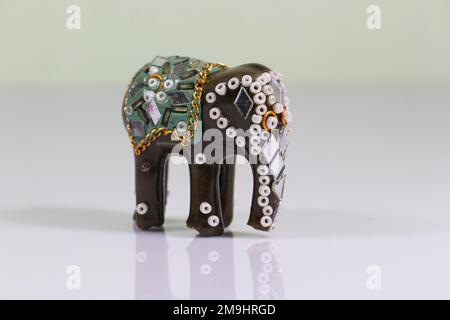 Souvenir tradizionale indiano. Scultura decorativa di elefante su sfondo specchio Foto Stock