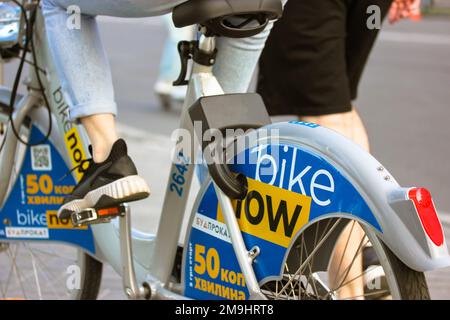 Kiev, Ucraina. 7 maggio, 2020. Una ragazza in bicicletta noleggio pedalando. Servizio di noleggio bici ucraine Bike ora con logo giallo blu. Bike ora azienda da K Foto Stock