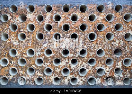 Piastra tubiera in lamiera di scambiatore di calore o di boiler closeup texture macro fondo industriale con insolubile depositi minerali duri saldatura a scala di sali Foto Stock