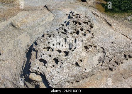 buchi di erosione della roccia vicino al mare Foto Stock