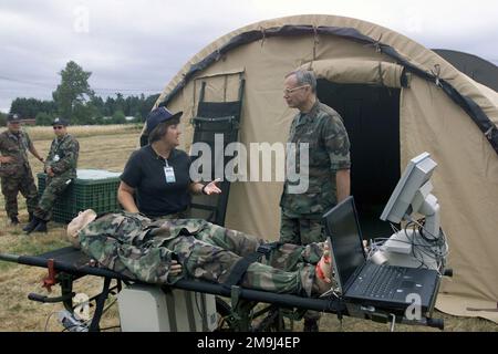 020717-F-5735S-015. [Complete] Scene Caption: US Air Force (USAF) Major (MAJ) Ann Lewandowski (a sinistra) descrive il funzionamento del manichino di ausilio all'addestramento chiamato SimMan, un simulatore di paziente universale, a USAF Brigadier General (BGEN) Joseph E. Kelley, Assistente chirurgo Generale di operazioni di spedizione, Scienza e tecnologia, Durante la visita di BGEN Kelleys presso la tenda dell'ospedale Expeditionary Medical System (EMEDS) a Fort Lewis, Washington (WA), durante l'esercizio SEAHAWK 2002. Seahawk combina componenti attivi di servizio e di riserva dell'aviazione militare US Air Force (USAF), della marina militare US (USN), della guardia costiera statunitense (USCG), USA Foto Stock