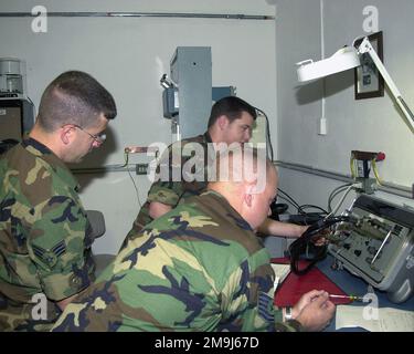 US Air Force Reserve (USAFR) SENIOR AIRMAN (SRA) Daniel Ratzel (sinistra) e USAFR Technical Sergeant (TSGT) Robert Fisher (destra), entrambi assegnati al volo di comunicazione 910th, osservano US Air Force (USAF) AIRMAN First Class (A1C) James Matthews, 31Communications Squadron, mentre esegue un controllo diagnostico sulle apparecchiature di crittografia del trunk KG-194. Sia SRA Ratzel che TSGT Fisher sono schierati alla Aviano Air base (AB), Italia, per il loro tour annuale di due settimane. Base: Aviano Air base Stato: Pordenone Nazione: Italia (ITA) Foto Stock