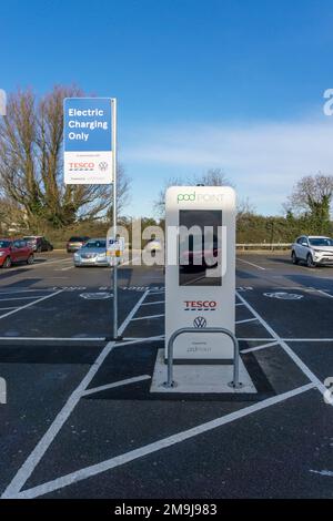 Pod Point EV punto di ricarica in un supermercato Tesco parcheggio. Foto Stock