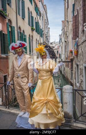 Artisti di strada veneziani mascherati vestiti in costumi da carnevale che si esibiscono per turisti a Venezia. Foto Stock