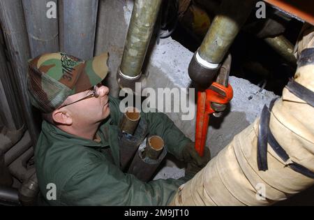 US Air Force (USAF) STAFF Sergente (SSGT) Phil Hill, 374th Civil Engineering Squadron (CES), Yokota Air base (AB), Giappone, lavora sui tubi collegati ad un'unità di riscaldamento situata nell'alloggiamento di base. Il CES sta attualmente disattivando le vecchie unità e installando le nuove linee stesse, risparmiando la base $30.000. (Immagine duplicata, vedere anche DFSD0415182 o cercare 030124F3798Y001). Base: Yokota Air base Paese: Giappone (JPN) scena comando principale mostrato: PACAF Foto Stock