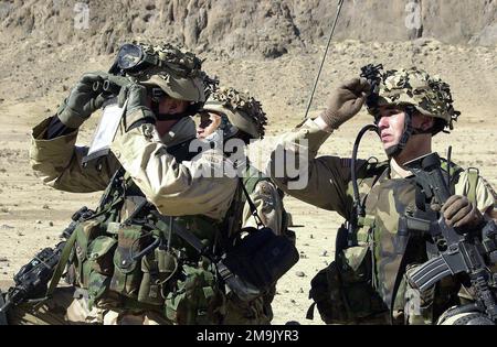 Primo tenente (1LT) James Bourie guarda attraverso binocoli per un percorso fino alle montagne di Gar ADI, mentre operatore radio, privato di prima classe (PFC) Thuam Nguyen con 'A' Company, 2nd battaglione, 504th Parachute Infanty Regiment (PIR), stand-by, a sostegno dell'operazione CHE PERCORRE LA LIBERTÀ. Oggetto operazione/Serie: LIBERTÀ DUREVOLE Paese: Afghanistan (AFG) Foto Stock