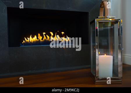 Camino e fuoco illuminato, interno in nuova casa di lusso Foto Stock