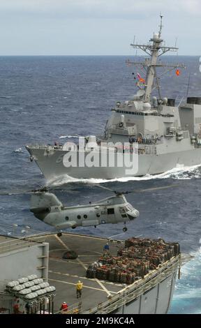 La US Navy (USN) Arleigh Burke Class Guided Missile Destroyer USS LASSEN (DDG 82) si affianca alla USN Sacramento Class Fast Combat Support Ship USS SACRAMENTO (AOE 1) durante un rifornimento in corso (UNREP) e un rifornimento verticale (VERTREP). Il cavaliere di mare USN H-46 dallo Squadrone 11 (HC-11) di supporto ai combattimenti in elicottero, Gunbearers, si trova in posizione per prelevare il carico per il trasferimento. Le navi fanno parte del vettore aereo USN Nimitz Class USS CARL VINSON (CVN 70) Carrier Strike Group (CSG) che conduce operazioni nell'Oceano Pacifico. Paese: Oceano Pacifico (POC) Foto Stock