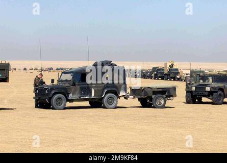 Un veicolo di comunicazione Land Rover britannico viene messo in scena per spostarsi con i veicoli RMCOC (Regimental Main Command Operations Center) del corpo marino statunitense (USMC), a nord di Kuwait City, Kuwait, a sostegno di operazioni CHE DURANO LA LIBERTÀ. Subject Operation/Series: ENDURING FREEDOM Nazione: Kuwait (KWT) Foto Stock