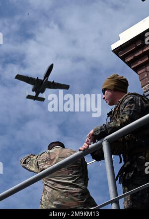 Un aereo A-10C Thunderbolt II assegnato al 104th Fighter Squadron, Maryland Air National Guard, sorvola due membri del servizio statunitense della gamma Kazlų Rūda in Lituania durante IL DEFENDER-Europe 22, 19 maggio 2022. Gli Stati Uniti L'esercizio congiunto su larga scala e multinazionale guidato dall'esercito mira a costruire la preparazione e l'interoperabilità tra le forze armate statunitensi, NATO e partner. Foto Stock