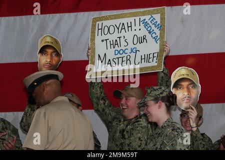 I marinai assegnati al dipartimento medico della USS Gerald R. Ford (CVN 78) allietano il Master Chief Hospital Corpsman Phillip Jean-Gilles durante la cerimonia di insignimento del Master Chief e Senior Chief Petty Officer della Ford, il 20 maggio 2022. Durante la cerimonia sono stati chiusi sei capi principali e 16 capi senior. Ford è nella stazione navale di Norfolk del porto che si prepara per il relativo periodo seguente in corso. Foto Stock