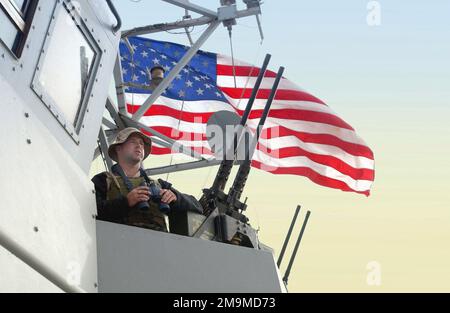 US Navy (USN) Boatswain's Mate Second Class (BM2) Ron Spencer, scandisce l'orizzonte per contatti e potenziali aggressori dalla nave di pattuglia costiera della classe Cyclone USS CHINOOK (PC 9) a sostegno dell'operazione IRACHENA LIBERTÀ. Operazione/Serie: BASE DELLA LIBERTÀ IRACHENA: USS Chinook (PC 9) Foto Stock