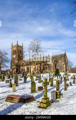 Il cimitero innevato e le lapidi nella parrocchia di Santa Maria chiesa Sandbach Cheshire Inghilterra in inverno Foto Stock