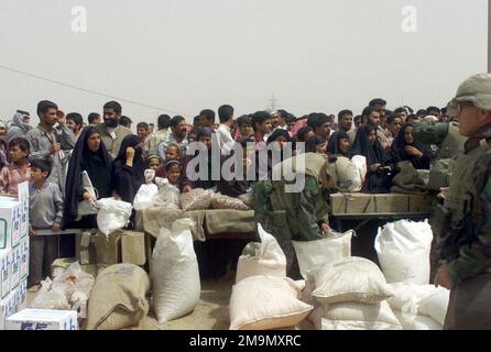 I marine STATUNITENSI (USMC) i marines assegnati alla Task Force (TF) Tarawa distribuiscono forniture alimentari donate ai cittadini iracheni locali nella città di un Nasariyah, in Iraq, durante l'operazione LA LIBERTÀ IRACHENA. Base: An Nasariyah Stato: Dhi Qar Paese: Iraq (IRQ) Foto Stock