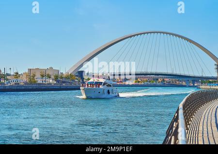 La barca turistica sul canale d'acqua di Dubai con una vista sul Ponte di tolleranza sullo sfondo, Dubai, Emirati Arabi Uniti Foto Stock