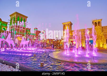 DUBAI, Emirati Arabi Uniti - 6 MARZO 2020: Le colorate fontane danzanti in Piazza della Cultura del Villaggio Globale di Dubai, con una vista sulle torri barjeel (windcatchers) di Foto Stock