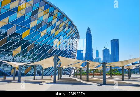 DUBAI, Emirati Arabi Uniti - 6 MARZO 2020: Esterno della moderna Coca-Cola Arena con un gruppo di ombrelloni e torri futuristiche sullo sfondo, il 6 marzo a Dubai Foto Stock