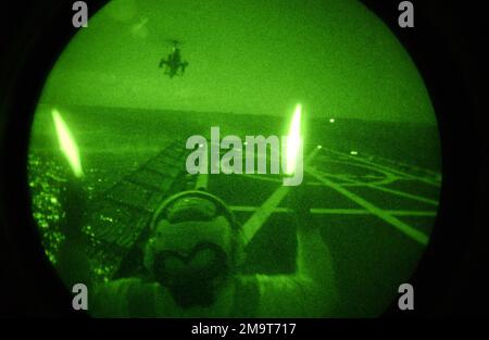 US Navy (USN) Sailor al Perrin, utilizza le bacchette leggere per guidare un elicottero AH-1W Super Cobra Attack su un ponte di atterraggio a bordo dell'Helicopter Landing Trainer, Baylander (IX-514), mentre si è in corso a Pensacola Bay. Stato: Florida Paese: Stati Uniti d'America (USA) Foto Stock