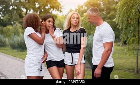 Amici adolescenti di gruppo multietnico. afroamericano asiatico caucasico studente passare il tempo insieme amicizia multirazziale felice sorridente persone vestito bianco nero sportswear incontro all'aperto Foto Stock