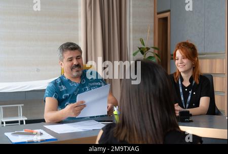 Medico che guarda le immagini ecografiche, medico che esamina ecografia di una paziente femminile e che parla con la donna della sua malattia Foto Stock