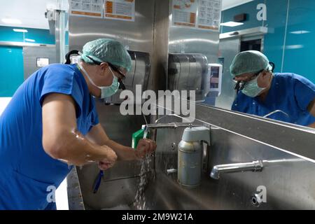 Medico di chirurgia a cuore aperto eseguire chirurgia a cuore aperto. Medici in uniformi verdi sono in sala operatoria Foto Stock