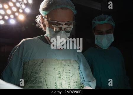 Medico di chirurgia a cuore aperto eseguire chirurgia a cuore aperto. Medici in uniformi verdi sono in sala operatoria Foto Stock