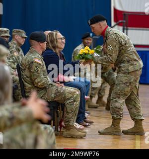 Un soldato di Ivy assegnato a 4th divisione di fanteria consegna un bouquet di fiori alla moglie del comando Sgt. Major. Donald Durgin, comando entrante Sgt. Major. Di 4th INF. Div Artiglieria, 20 maggio 2022, durante una cerimonia di Assunzione del comando, a Fort Carson, Colorado. La presentazione delle rose gialle è un simbolo del suo continuo amore e sostegno. Foto Stock