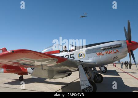 040306-F-3208M-022. Apollo 8 astronauta e US Air Force (USAF) Brigadier General (BGEN) Bill Anders, (USAF, in pensione) guarda un F-16 Fighting Falcon e un P-51 Mustang inseguimento (combattente) aereo volare in formazione mentre si siede nella cabina di pilotaggio di una seconda guerra mondiale (WW II) Era P-51 Mustang inseguimento (combattente) aereo in attesa di volare e partecipare alla Heritage Conference che si svolge presso Davis-Montham Air Force base (AFB), Arizona (AZ). Foto Stock