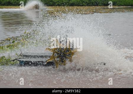 Il waterwheel agita la superficie dell'acqua in un laghetto di trattamento delle acque reflue. Foto Stock