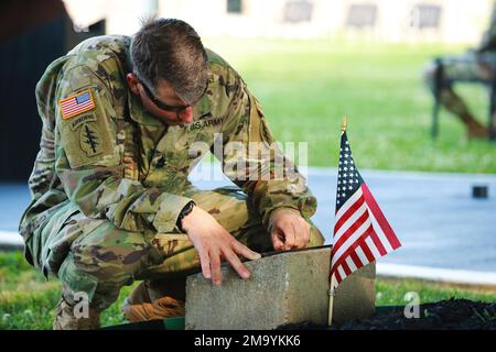 A Soldier of 5th Special Forces Group (Airborne), pulisce una targa commemorativa prima della cerimonia annuale della Gold Star sul campo di Gabriel a Fort Campbell, Ky., 21 maggio 2022. La cerimonia di commemorazione onora le famiglie degli eroi delle operazioni speciali caduti. Foto Stock