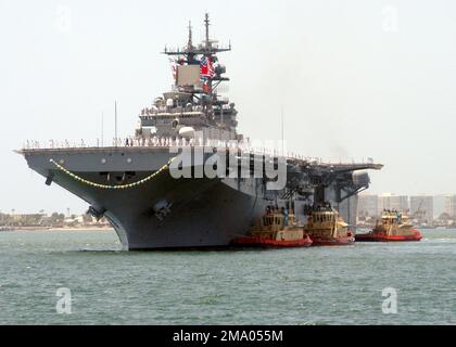 Vista di prua del porto della Marina militare americana (USN) classe WASP: Nave da assalto anfibio, USS BOXER (LHD 4), che mostra i marinai che presergono le rotaie mentre la nave è assistita da rimorchiatori commerciali come torna a casa alla base navale di San Diego, California (CA), a seguito di un dispiegamento a sostegno dell'operazione DI LIBERTÀ IRACHENA. Base: San Diego Stato: California (CA) Paese: Stati Uniti d'America (USA) Foto Stock
