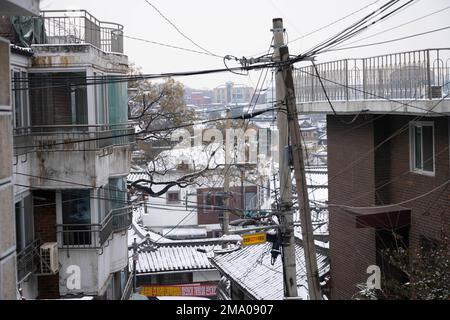 Seul, Corea. 21st Dec, 2022. Scene di strada del Villaggio di Bukchon Hanok. Il Villaggio di Bukchon Hanok e' un quartiere unico e affascinante situato nel cuore di Seoul. Ospita molte case tradizionali in stile coreano, note come anoks, che sono state conservate o ricostruite per centinaia di anni. Il villaggio è costituito da vicoli tortuosi e da edifici tradizionali, molti dei quali sono aperti al pubblico come musei, centri culturali e tradizionali case da tè. E' un luogo perfetto per vedere e conoscere la tradizionale architettura e cultura Coreana. I visitatori possono esplorare il villaggio e vedere come il tr Foto Stock