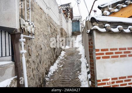 Seul, Corea. 21st Dec, 2022. Scene di strada del Villaggio di Bukchon Hanok. Il Villaggio di Bukchon Hanok e' un quartiere unico e affascinante situato nel cuore di Seoul. Ospita molte case tradizionali in stile coreano, note come anoks, che sono state conservate o ricostruite per centinaia di anni. Il villaggio è costituito da vicoli tortuosi e da edifici tradizionali, molti dei quali sono aperti al pubblico come musei, centri culturali e tradizionali case da tè. E' un luogo perfetto per vedere e conoscere la tradizionale architettura e cultura Coreana. I visitatori possono esplorare il villaggio e vedere come il tr Foto Stock