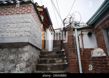 Seul, Corea. 21st Dec, 2022. Scene di strada del Villaggio di Bukchon Hanok. Il Villaggio di Bukchon Hanok e' un quartiere unico e affascinante situato nel cuore di Seoul. Ospita molte case tradizionali in stile coreano, note come anoks, che sono state conservate o ricostruite per centinaia di anni. Il villaggio è costituito da vicoli tortuosi e da edifici tradizionali, molti dei quali sono aperti al pubblico come musei, centri culturali e tradizionali case da tè. E' un luogo perfetto per vedere e conoscere la tradizionale architettura e cultura Coreana. I visitatori possono esplorare il villaggio e vedere come il tr Foto Stock