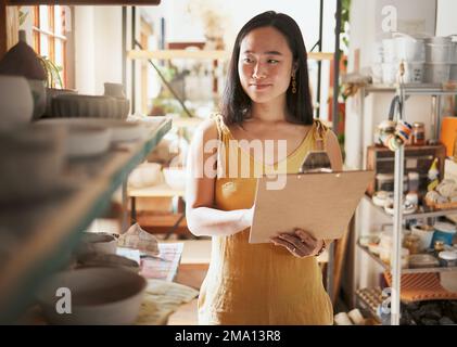Il controllo del magazzino della cucina, la donna asiatica ed i dati della clipboard di un imprenditore controllano le informazioni del deposito. Felice, sorriso e lavoratore di startup occupato a lavorare su un Foto Stock
