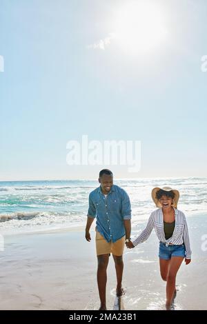 Felice, ridente e coppia nera che tiene le mani alla spiaggia per amore, libertà e fiducia in Bali. Viaggia, sorridi e uomo e donna neri camminando accanto al Foto Stock