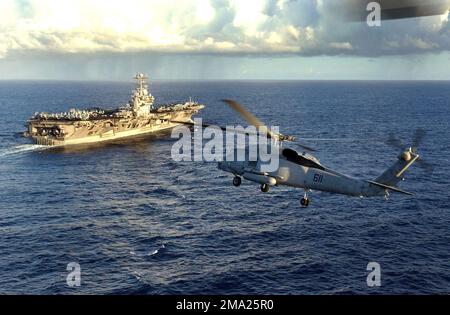 040706-N-5923E-098. [Complete] Scene Caption: A US Navy (USN) SH-60F elicottero Seahawk, elicottero Anti-Submarine Squadron 4 (HS-4), Black Knights, Naval Air Station North Island (NASNI) vola come guardie del canale per il portaerei USN Nimitz Class USS JOHN C. STENNIS (CVN 74). La STENNIS e la Carrier Air Wing quattordici (CVW-14) partecipano all'esercizio marittimo multinazionale RIM DEL PACIFICO 2004 (RIMPAC). RIMPAC è il più grande esercizio marittimo internazionale nelle acque intorno alle isole hawaiane. Questo esercizio include sette nazioni: Australia, Canada, Cile, Giappone, così Foto Stock